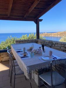 a table on a patio with a view of the ocean at Boutique Villa Olivia in Agios Pavlos