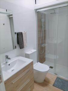 y baño con aseo, lavabo y ducha. en Apartamento D&L en Costa del Silencio