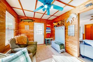 a living room with wooden walls and a ceiling fan at The Cove - Main House in Golden