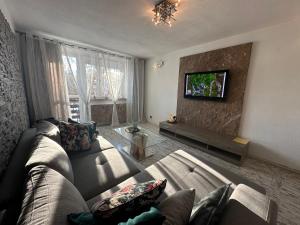 uma sala de estar com um sofá e uma televisão de ecrã plano em Apartment Ustroń em Ustroń
