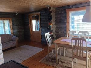 a dining room with a table and chairs in a cabin at Akolampi cottage in Impiö