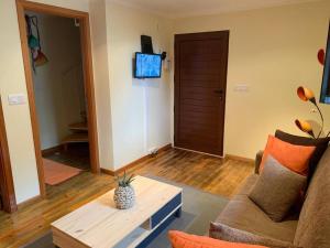 a living room with a couch and a coffee table at Cozy chalet with ocean view in Seixal
