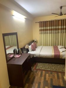 a hotel room with two beds and a desk at Rameshworam Hotel in Kathmandu