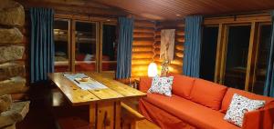 a living room with a couch and a wooden table at Korvala log cabins in Korvala