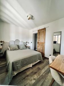 een slaapkamer met een groot bed en een houten vloer bij L Arancera - Sant Anghjulu - Appartement cosy in Penta-di-Casinca