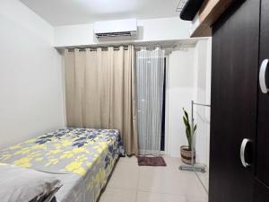 a bedroom with a bed and a air conditioner at Studio Units at Shore Residences Condo MOA Complex near Airport in Manila