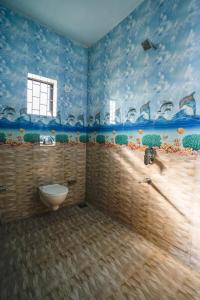 a bathroom with a toilet in a room with blue walls at Hotel Pasquina Baga in Baga