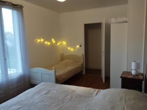 a bedroom with two beds and lights on the wall at Les petits cailloux in Saint-Médard-de-Mussidan +3 photos