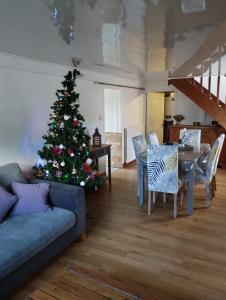 a christmas tree in a living room with a blue couch at Les petits cailloux in Saint-Médard-de-Mussidan