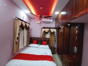 a bedroom with a bed with red pillows and a ceiling at Alif Serviced (Hotel) Apartments in Tambaram