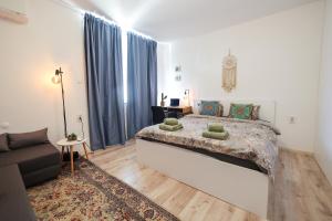 Schlafzimmer mit einem großen Bett und blauen Vorhängen in der Unterkunft City Park Apartment in Goze Deltschew