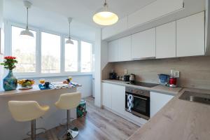 eine Küche mit weißen Schränken und Holzböden in der Unterkunft City Park Apartment in Goze Deltschew