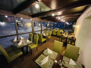 a dining room with tables and green chairs at Hotel Pruggererhof in Pruggern