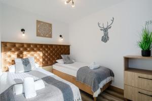 een slaapkamer met 2 bedden en een dressoir bij Tatra View 2 Apartamenty Księżycowe SPA in Zakopane
