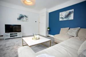 a living room with a couch and a tv at A Piece of Seaside Serenity on the Sandbanks Peninsula in Sandbanks