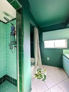 a green bathroom with a shower and a toilet at Relaxing 6 BR Oasis with Pool - Lou1 in Los Angeles