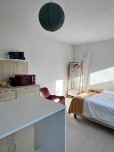 a white room with a bed and a table and a chair at Maria Studio in Cascais