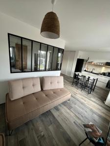 een woonkamer met een bank en een tafel bij L Arancera - Sant Anghjulu - Appartement cosy in Penta-di-Casinca