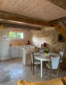 eine Küche mit einem Tisch und Stühlen im Zimmer in der Unterkunft Mas provençal in Camaret-sur-Aigues