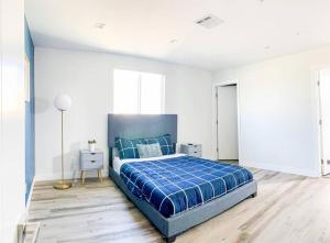 a bedroom with a blue bed in a white room at Spacious Townhouse in Mid City - CR4-WIN in Los Angeles