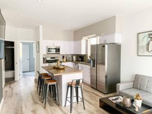 a kitchen with white cabinets and a kitchen island with bar stools at Spacious Townhouse in Mid City - CR4-WIN in Los Angeles