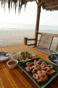 uma mesa com um prato de comida na praia em Pranee Beach Bungalows em Ko Kho Khao