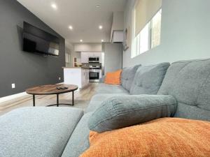Sala de estar con sofá gris y mesa en Ideal Townhouse in Mid City - CR1-CUL, en Los Ángeles