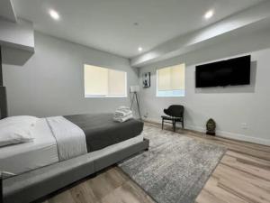 a bedroom with a large bed and a flat screen tv at Ideal Townhouse in Mid City - CR1-CUL in Los Angeles