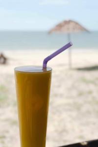 a drink sitting on a table on the beach at Pranee Beach Bungalows in Ko Kho Khao