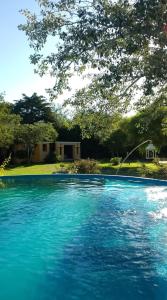 una gran piscina de agua azul frente a una casa en El Cimarron Casa de Campo en La Granja