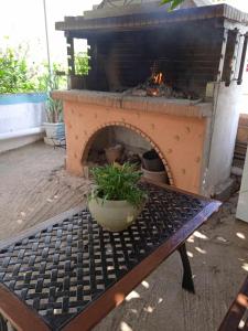 a outdoor fireplace with a table with a plant on it at Margaritas Cottage in Nafplio