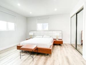 a white bedroom with a large bed and two windows at Stylish Townhouse in Mid City - CR2-CUL in Los Angeles