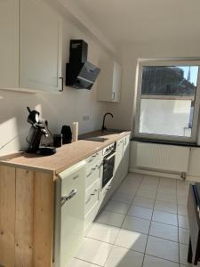 uma cozinha com armários brancos, um lavatório e uma janela em Monteur- & Ferienwohnungen in Dorsten Altstadt - ZENTRUM - NEU saniert em Dorsten