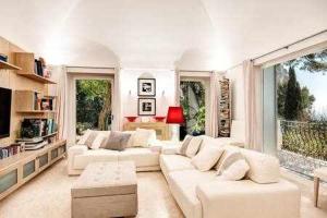 sala de estar con muebles blancos y ventana grande en Villa Bouganvillea Superb Capri Villa with Views, en Capri