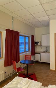 een kamer met een tafel en 2 stoelen en een keuken bij Trestads Värdshus in Vänersborg