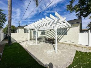 a white pergola with chairs and tables in a yard at Cozy 3BR Oasis for Your Next Adventure in LA - WO in Los Angeles