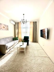 ein Wohnzimmer mit Sofa und Tisch in der Unterkunft Двухкомнатная квартира в жилом доме ЖК Арман/ One-bedroom apartment in Arman residential complex in Atyrau