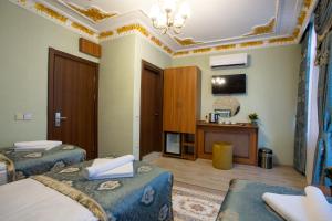 a hotel room with two beds and a television at Sayina Hotel in Istanbul