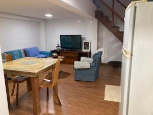 a living room with a table and a tv at Loft no Retiro in Brumadinho