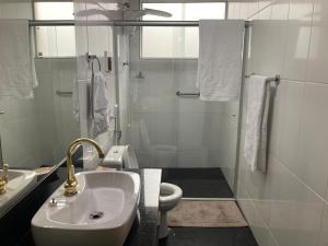 a bathroom with a sink and a toilet and a shower at Loft no Retiro in Brumadinho