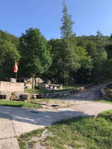 une route avec un mur en pierre et des arbres en arrière-plan dans l'établissement Nice cabin, à Cetinje