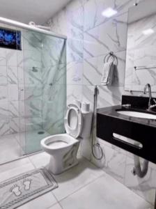 uma casa de banho com um WC, um chuveiro e um lavatório. em CHALES TEMATICOS em Belterra