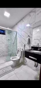 La salle de bains est pourvue de toilettes, d'une douche et d'un lavabo. dans l'établissement CHALES TEMATICOS, à Belterra