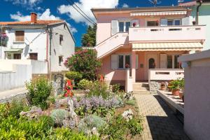 a house with a garden in front of it at Apartment Oleander in Punat