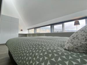 a bedroom with a large bed with a pillow and windows at Departamento duplex diseño exclusivo in Huancayo