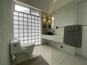a bathroom with a toilet and a sink and a window at Departamento duplex diseño exclusivo in Huancayo