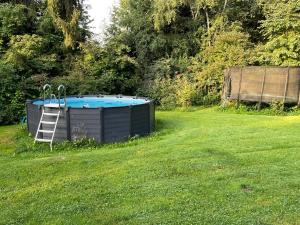 a pool in a yard with a ladder next to it at Gästehaus Grünberger in Hutthurm