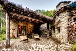 een stenen huis met 2 stoelen en een patio bij Il Mulino in Ortignano Raggiolo