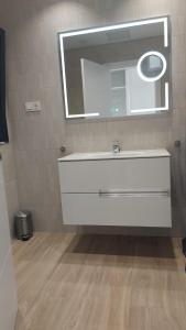 W łazience znajduje się biała umywalka i lustro. w obiekcie Luxury Apartment in Casilla de Costa - Casa MEVA w mieście Lajares