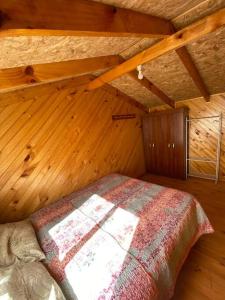 ein Schlafzimmer mit einem Bett in einem Holzzimmer in der Unterkunft Cabañas León in Ancud